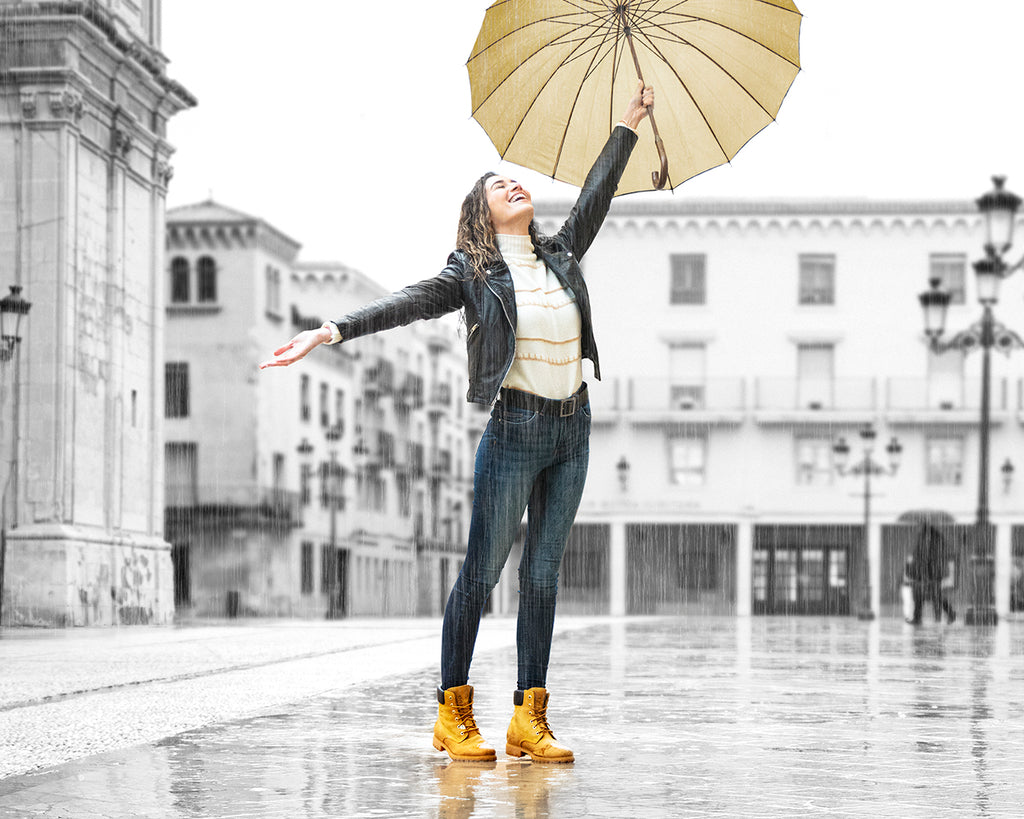 Chica sonriendo bajo la lluvia